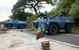 Des véhicules de la gendarmerie en opération sur un barrage dressé par des indépendantistes, le 19 mai 2024 à La Pirogue, sur la commune de Paita en Nouvelle-Calédonie