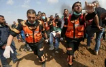 Des Palestiniens transportent un homme blessé lors d'affrontements avec les forces israéliennes près de la frontière entre la bande de Gaza et Israël le 27 avril 2018