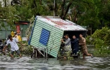 Des hommes dégagent les débris dans une rue inondée de Haiphong, après le passage du typhon Yagi, le 8 septembre 20244 au Vietnam
