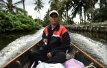 Nopadol, postier, distribue des lettres et colis aux habitants vivant sur les bords d'un canal dans la province de Bang Khun Thian, près de Bangkok en Thaïlande, le 17 juillet 2017