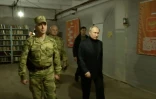 Image tirée d'une vidéo diffusée par la présidence russe le 18 avril 2023, du président russe Vladimir Poutine (d) visitant le GQ des forces russes dans la région de Lougansk, en Ukraine