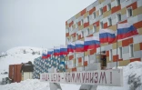 Une inscription en lettres cyrilliques rouges "Notre objectif: le communisme!" devant un immeuble de Barentsburg, le 7 mai 2022 dans l'archipel de Svalbard, dans le nord de la Norvège