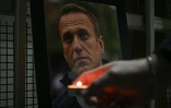 Une personne allume une bougie devant un portrait de l'opposant russe Alexeï Navalny, mort en prison, le 20 février 2024 à Pristina, au Kosovo