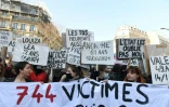 Des femmes dénoncent sur des pancartes les victimes de violences conjugales en France, lors d'une manifestation le 8 mars 2022 à Paris pour la journée internationale pour les droits des femmes