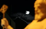 La lune est visible derrière une statue du tsar Samouil, l'un des derniers souverains bulgares avant la domination byzantine, au centre de Skopje, en Macédoine du Nord, le 25 mai 2013