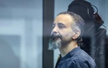 L'accusé saoudien Taleb Jawad al-Abdulmohsen (c) dans le box en verre pare-balle de la salle d'audience provisoire de Magdebourg, lors de son procès pour avoir foncé avec un SUV dans la foule d'un marché de Noël fin 2024, le 26 juin 2026 dans l'est de l'Allemagne