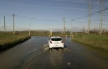Une voiture roule sur une route inondée à Tonneins dans le Lot-et-Garonne le 24 janvier 2018