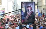 Un partisan du président vénézuélien déchu Nicolas Maduro brandit son portrait lors d'un rassemblement devant l'Assemblée nationale à Caracas le 5 janvier 2026