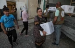 Des déplacés yazidis recevant des cartons remplis d'aides alimentaires dans le camp de Chamishko, dans le nord de l'Irak, le 5 mai 2022