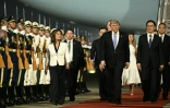 Le président américain Donald Trump (c) accompagné par le vice-président chinois Han Zheng (d) passe en revue la garde d'honneur à son arrivée à l'aéroport international de Pékin, le 13 mai 2026