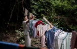 Une femme, déplacée par les combats entre l'armée birmane et l'Armée de l'indépendance kachin (KIA), étend du linge sur le terrain d'un monastère à Mandalay, le 16 septembre 2025 en Birmanie
