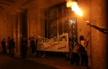 Des militants indépendantistes catalans accrochent une banderole sur un bâtiment public de Barcelone lundi 1er octobre, premier anniversaire du référendum sur l'indépendance de la Catalogne