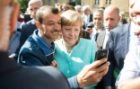 Un demandeur d'asile fait un selfie avec la chancelière allemande Angela Merkel, le 10 septembre 2015 à Berlin