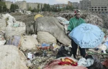 Le créateur de mode Morgan Azedy fouille dans des piles de vêtements mis au rebut dans une décharge à Nairobi, le 6 octobre 2025 au Kenya
