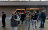 Des habitants observent un immeuble résidentiel endommagé après une frappe de drone russe à Kiev, le 25 septembre 2026
