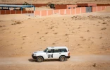 Un véhicule de la mission de maintien de la paix de l'ONU au Sahara occidental (Minurso) circule du côté marocain du point de passage frontalier entre le Maroc et la Mauritanie à Guerguerat, au Sahara occidental, le 25 novembre 2020