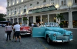 De vieilles voitures de luxe américaines devant l'entrée de l'hôtel Gran Manzana à Cuba, le 11 février 2019