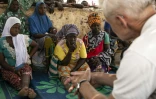 Le secrétaire général du Conseil norvégien pour les réfugiés, Jan Egeland, parle avec des déplacées du camp de Torodi, à Dori, dans le nord-est du Burkina Faso, le 30 mai 2024