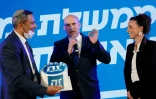 Naftali Bennett (au centre), leader du parti israélien "Nouvelle Droite", s'exprime sur scène lors d'un rassemblement de campagne dans la ville de Sderot, dans le sud d'Israël, le 17 mars 2021, avant les législatives le 23 mars