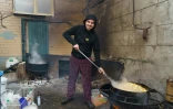 Un bénévole fait cuire des pommes de terre au restaurant Belouga où l'on prépare des repas distribués dans les territoires occupés par l'armée russe, le 4 avril 2022 à Zaporijjia, en Ukraine
