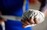 Un joueur de lethwei se bande les mains lors d'un entraînement dans un club de Rangoun, le 18 décembre 2015