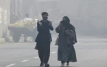 Des promeneurs affrontent le smog dans les rues de Lahore le 2 novembre 2024. 