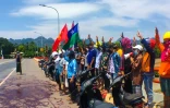 Photo diffusée par Eindu Youths le 6 avril 2021 montrant des manifestants faisant le salut à trois doigts et déversant de la peinture rouge sur une route à Hpa-an, capitale de l'Etat Karen, dans le sud de la Birmanie
