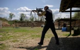 Vadim Mirnichenk teste au fusil la solidité des plaques de protection pare-balles qu'il fabrique dans son atelier, le 1er mai 2022 à Zaporijjia, en Ukraine