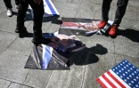 Des manifestants piétinent des photos du président américain Donald Trump et du Premier ministre israélien Benjamin Netanyahu, le 24 juillet 2026 à Caracas