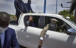 Le colonel malien Assimi Goïta, président du gouvernement de transition, salue depuis sa voiture le 31 mai 2021 à Bamako, de retour d'un sommet extraordinaire sur le Mali au Ghana