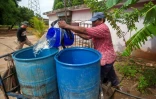 Un homme remplit un fût d'eau dans un quartier de Maracaibo, dans l'État de Zulia, au Venezuela, le 21 juin 2025