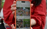 Une touriste chinoise, originaire de la province du Hunan, montre son compte Xiaohongshu sur son téléphone portable alors qu'elle visite la Cité interdite à Pékin, le 11 juillet 2026
