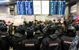 Des policiers font face à des manifestants dans un terminal de l'aéroport Vnoukovo de Moscou, où était attendu le principal opposant russe Alexeï Navalny, le 17 janvier 2021