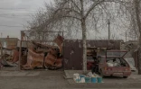 Un homme vend du lait et d'autres produits près d'habitations endommagées par les bombardements à Lyman, dans la région de Donetsk, le 1 février 2025