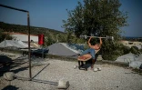 Un migrant fait de l'exercice devant sa tente près du camp de réfugiés de Moria, sur l'île grecque de Lesbos, le 1er septembre 2019