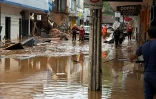 Photo fournie par le Service incendie du Minas Gerais montrant des pompiers dans une rue inondée après des fortes pluies à Juiz de Fora, dans l'Etat du Minas Gerais, le 24 février 2026 au Brésil