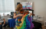 La violoniste Angelina DM Trailz joue avec une robe aux couleurs du drapeau LGBTQ, au centre Law Harrington, à Houston au Texas, le 24 juin 2021