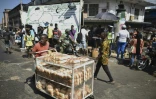 Un vendeur ambulant de pain dans une rue de Freetown, le 27 novembre 2023 en Sierra Leone