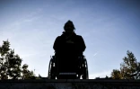 Un homme en chaise roulante pose devant les escaliers d'une station de métro à Paris, lors d'une manifestation de l'association APF France Handicap, le 26 septembre 2018
