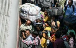 Des habitants tentent de monter dans un train à la gare de Jammu, le 10 mai 2025 au Cachemire indien