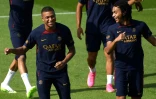 L'attaquant français du Paris Saint-Germain Kylian Mbappé (g.) et son jeune frère Ethan Mbappé, milieu de terrain français du Paris Saint-Germain, lors d'une séance d'entraînement sur le nouveau "campus" du PSG à Poissy, le 20 juillet 2023