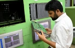 Un employé inspecte une plaque de circuits dans la salle de contrôle de l'usine d'engrais de Ashuganj, à l'arrêt depuis un an, le 12 août 2026 à Brahmanbaria, dans l'est du Bangladesh