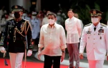 Le président philippin sortant Rodrigo Duterte (au centre à gauche) sous le regard du président entrant Ferdinand Marcos Jr (derrière au centre à droite), lors de la cérémonie d'investiture dans l'enceinte du palais présidentiel de Malacanang à Manille le 30 juin 2022
