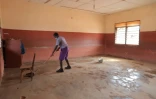Un élève nettoie une classe au premier jour de reprise des cours au Ghana, à Accra le 18 janvier 2021