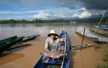 Le pêcheur thaïlandais Sawat Kaewdam montre ses prises le long des rives du Mékong, dans la région du Triangle d'or, dans la province de Chiang Rai, au nord de la Thaïlande, le 25 mai 2025