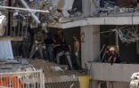 Secouristes et militaires israéliens fouillent les décombres d'un bâtiment lourdement endommagé par des tirs de missiles iraniens dans la ville côtière de Bat Yam, au sud de Tel-Aviv, le 15 juin 2025