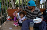 Photo prise le 23 août 2018 montrant un Vénézuélien et sa fille sur le bord d'une route à Boa Vista, dans l'Etat de Roraima au Brésil