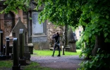 Un touriste photographie une stèle portant des noms similaires à plusieurs personnages de la saga Harry Potter créée par JK Rowling dans le cimetière Greyfriars, le 5 juin 2024 à Edimbourg, en Ecosse