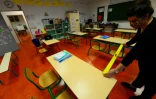 Une enseignante mesure la distance entre les tables dans une salle de classe, le 11 mai 2020 à Cenon, près de Bordeaux