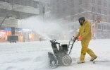 Un homme utilise un engin pour déblayer la neige dans les rues de New York, le 26 janvier 2016